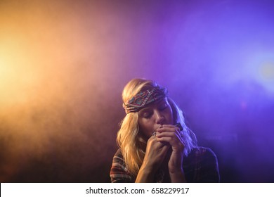 Beautiful female musician playing harmonica in nightclub - Powered by Shutterstock