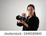 Beautiful female photographer with a dslr camera working at her studio