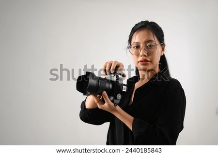Beautiful female photographer with a dslr camera working at her studio