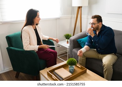 Beautiful Female Psychologist Giving A Glass Of Water To A Man With Depression. Patient Talking To The Therapist About The Suicide Attempt