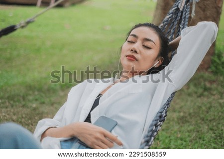 A beautiful female is sleeping or napping while listen to music by mobilephone and earphones. Concept of day off, realxation, comfort, day dreaming, entertainment, resting. mind relief sensory.