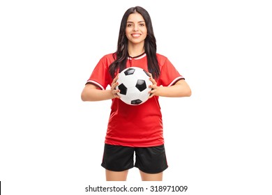 Beautiful female soccer player in red jersey holding a ball and looking at the camera isolated on white background - Powered by Shutterstock