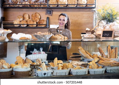 Beautiful Female Staff Selling Fresh Pastry And Baguettes In Local Bakery