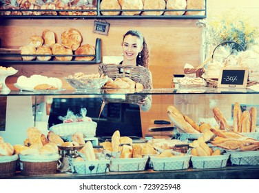 Beautiful Female Staff Selling Fresh Pastry And Baguettes In Local Bakery