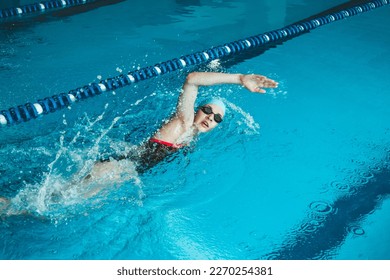 Beautiful female swimmer using front bypass, freestyle in the pool. Preparing professional athletes to win the championship - Powered by Shutterstock