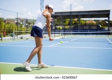 Beautiful female tennis player serving outdoor