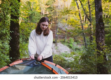 A Beautiful Female Tourist Setup A Tent. Camping In The Forest. Explore Nature