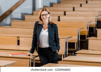 Beautiful Female University Professor Smiling And Looking At Camera In Classroom