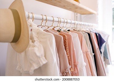 Beautiful female wardrobe. A lot of party dresses hanging on hangers in closet. Vintage clothing rental concept. Women's space.  Boho market. Small boutique showroom fashion shop. big choice