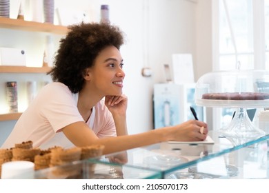 A Beautiful Female Worker In An Ice Cream Parlor Writes Down An Order.