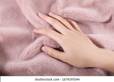 beautiful female's hand on the fabric of plush cloth with soft nap