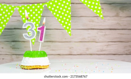 Beautiful festive background with the number 31 with a cake and lit candles, space saving for any holiday. Garland with birthday decorations for a postcard.Decorations are multi-colored festive.