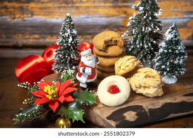 Beautiful festive Christmas vignette display baked goods cookies. Wood board, mini trees, satin ornaments, poinsettia, bell, Santa Claus figure. Ginger, shortbread, walnut. Sweet tooth. Festive noel. - Powered by Shutterstock