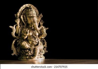 Beautiful figurine of Hindu god of wisdom, knowledge and new beginnings Ganesha against dark background.