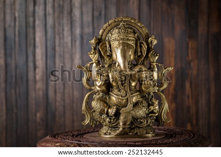 Beautiful figurine of Hindu god of wisdom, knowledge and new beginnings Ganesha against wooden background.