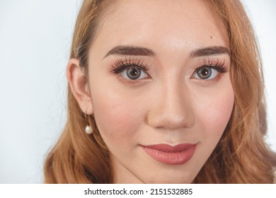 A Beautiful Filipina Model Showing The Results Of A Professional Makeup Session. Wearing Contact Lens And Sporting Brilliant Copper Dyed Hair.