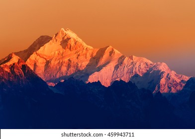 Beautiful first light from sunrise on Mount Kanchenjunga, Himalayan mountain range, Sikkim, India. Orange tint on the mountains at dawn