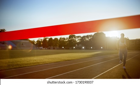 Beautiful Fit Female Runner Run Before Crossing The Finish Line On A Professional Sports Arena. Athletic Woman Competing At A Stadium. Celebrating Victory Achievement.