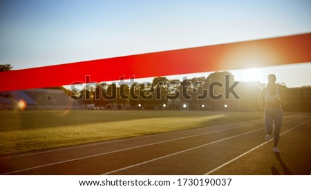 Beautiful Fit Female Runner Run Before Crossing the Finish Line on a Professional Sports Arena. Athletic Woman Competing at a Stadium. Celebrating Victory Achievement.
