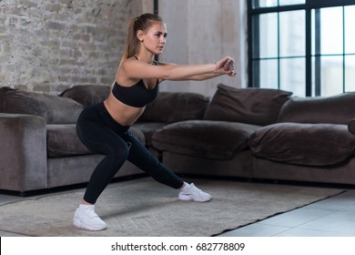 Beautiful fit girl doing home workout performing lateral lunges in a sitting room