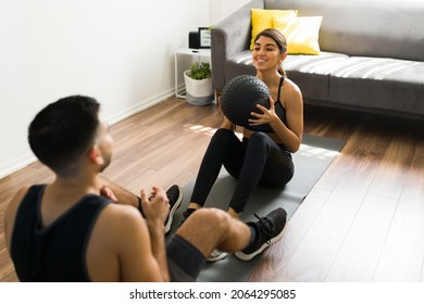 Beautiful Fit Woman In Activewear Throwing A Slam Ball To Her Workout Partner 