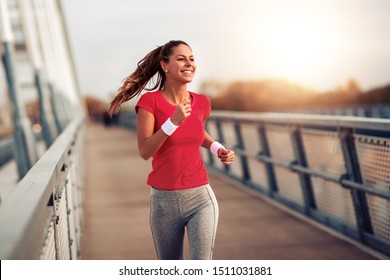 Beautiful Fit Woman In Good Shape Jogging Alone On City Bridge.