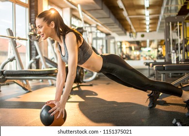 Beautiful Fit Young Woman Doing Push Up With Medicine Ball At Gym