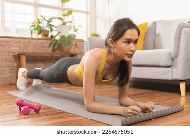 Beautiful fitness asian young woman, girl wearing sportswear training strength muscles workout, exercise training on carpet in living room at home for healthy body strong athletic fit active lifestyle - Shutterstock ID 2264675051