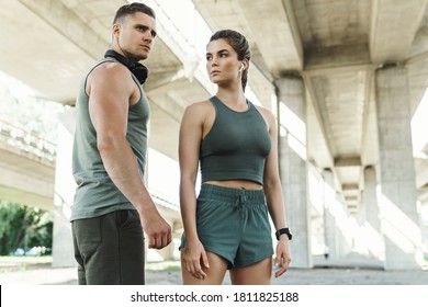Beautiful fitness couple wearing stylish sportive clothes are posing on a city street