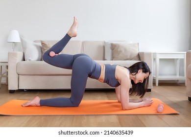 Beautiful Fitness female doing warmup workout at home. Fitness woman doing stretch exercise stretching her legs,quadriceps . Fit girl living an active lifestyle.