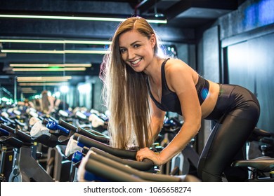 Beautiful Fitness Girl Training On Indoor Bike In Gym.