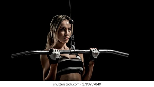 schöne Fitnessfrau übt sich mit einem Fitnessgerät auf schwarzem Hintergrund aus 