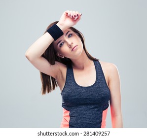 Beautiful Fitness Woman Wipes The Sweat From His Brow On Gray Background And Looking At Camera