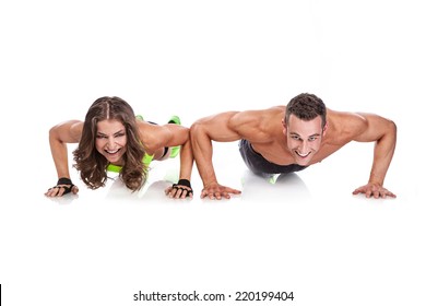 beautiful fitness young sporty couple doing push ups isolated over white background