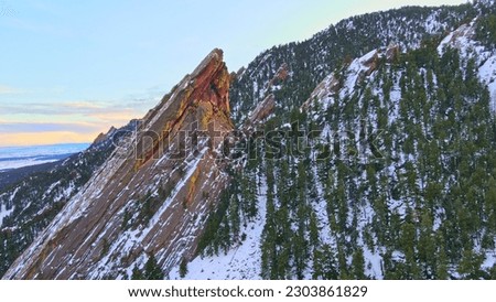 Beautiful flatirons of boulder Colorado covered in Snow during sunset