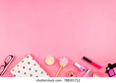 Beautiful flatlay with white planner, glasses, cosmetics and other accessories. Pink background, copyspace