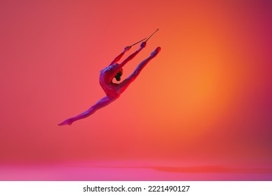 Beautiful and flexible graceful athlete rhythmic gymnastic artist dancing, doing stretch exercises isolated on colorful background in neon. Beauty, art, sport, competition, ad and hobbies concept - Powered by Shutterstock