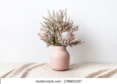 Beautiful floral arrangement including beautiful dried pink King Proteas and delicate thryptomene flowers, in a stylish pink vase. - Powered by Shutterstock