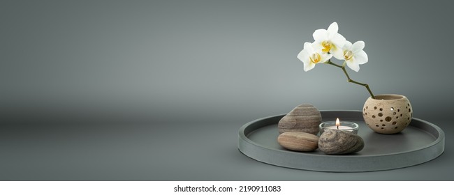 Beautiful Floral Home Decoration Composition With White Orchid And Candle On Grey Pure Background, Lifestyle Concept With Copy Space For Product Presentation