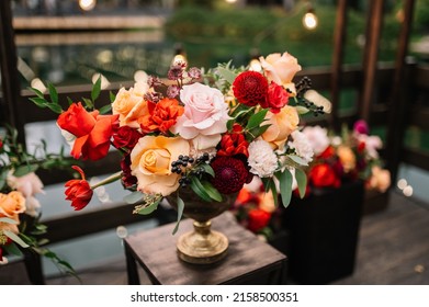 Beautiful flower composition with autumn orange and red flowers and berries. Autumn bouquet in vintage vase on a wooden table  - Powered by Shutterstock