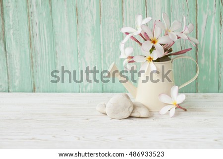 Beautiful flower in lovely jar on wood background.