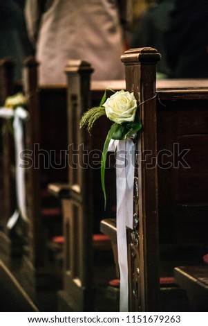 Beautiful flower wedding decoration in a church hang on the seat rows setting in the Chapel, ceremony selective focus