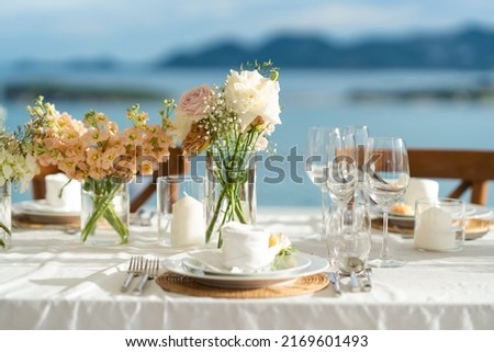 Beautiful flowers decorated on the table.Tables set for an event party or wedding reception. luxury elegant table setting dinner in a restaurant. glasses and dishes. Fancy moment fancy time.