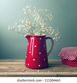 Beautiful Flowers In Red Jug On Wooden Table