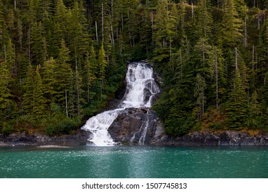 Beautiful flowing waterfall into the ocean in Endicott Arm fjord near Juneau Alaska