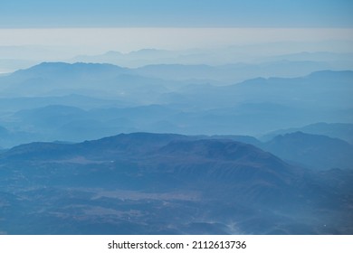 Beautiful foggy blue pastel mountainous abstract natural photo background. Mountain range with dark scenic wavy silhouettes Arkistovalokuva