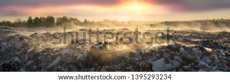 beautiful foggy dawn of the Sun over a huge field of urban garbage, saturated with poisonous fumes of decomposition of organic waste and household chemicals
