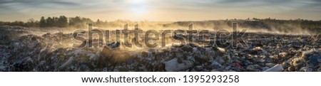 beautiful foggy dawn of the Sun over a huge field of urban garbage, saturated with poisonous fumes of decomposition of organic waste and household chemicals