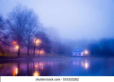 Beautiful foggy landscape at lake pond on misty winter night with illuminated lights - Powered by Shutterstock