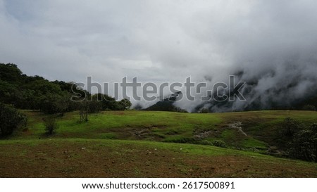 A beautiful foggy landscape of mountain range in the countryside covered in clouds